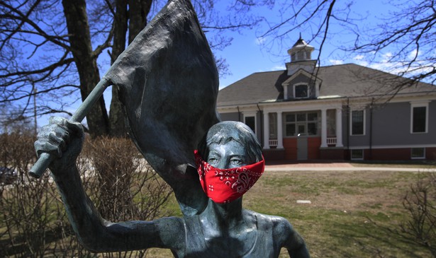 A statue of Olympic marathon gold medalist Joan Benoit Samuelson wears a red bandana mask outside the library in Cape Elizabeth, Maine