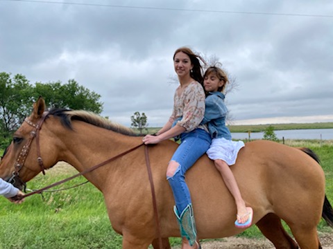 Two girls on horseback.