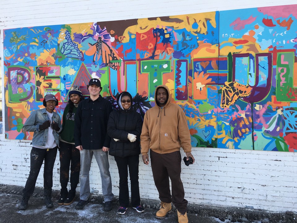 Mac Love (center) stands in front of a mural reading "beautiful" with fellow Art x Love team members Josy Jones, Dee McCall, Gaby Barnes, and Patrick Richards (left to right) who were a part of the @Play project in Akron. Photo courtesy of Art x Love.