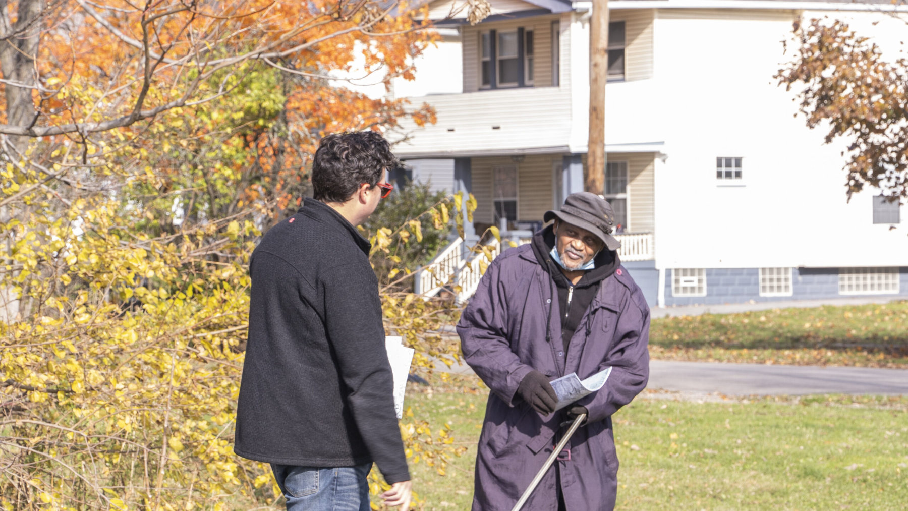 Mac Love (left) gives a Buckeye-Shaker resident a copy of The Village Activity Book. Photo by Cory Kistow, courtesy of Art x Love.