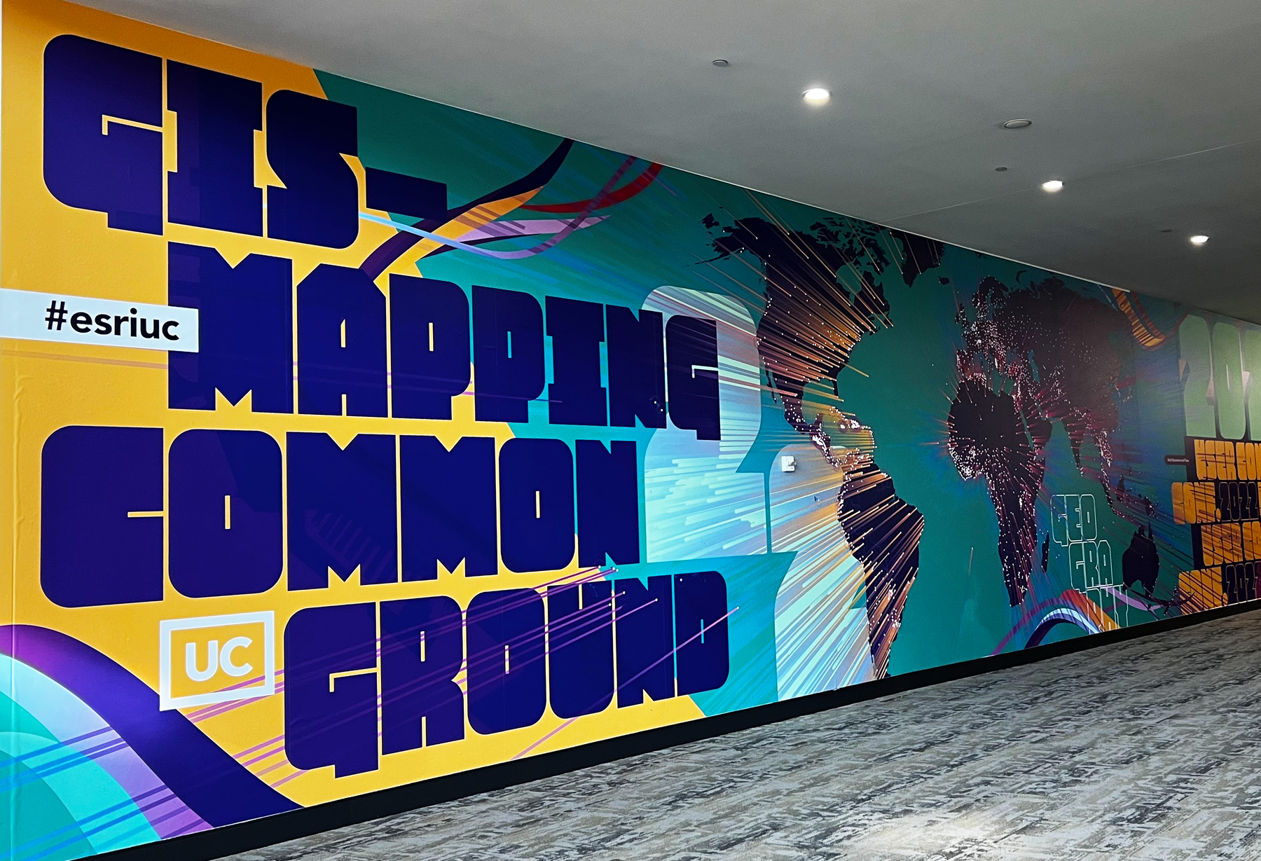 A wall canvas reading GIS -- Mapping Common Ground, as seen at the Esri 2022 User Conference in San Diego