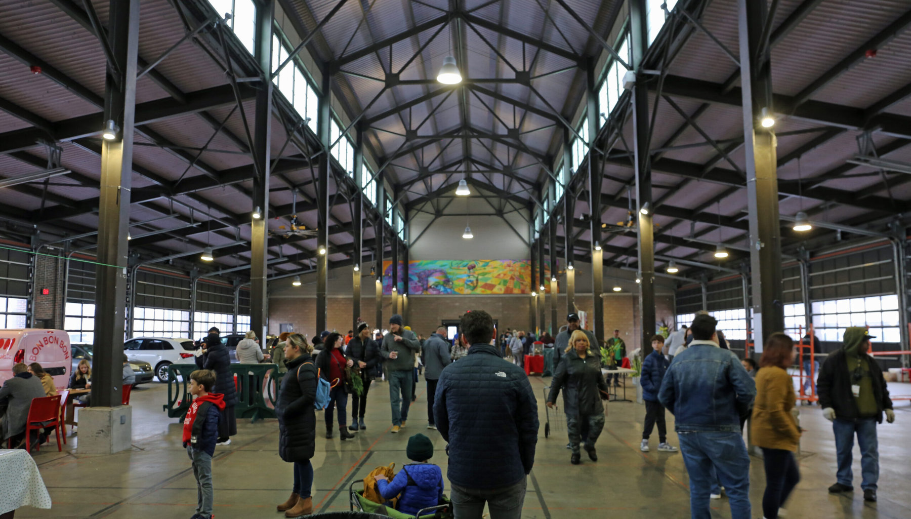 A loose crowd of people walking around the inside of Detroit's Eastern Market.