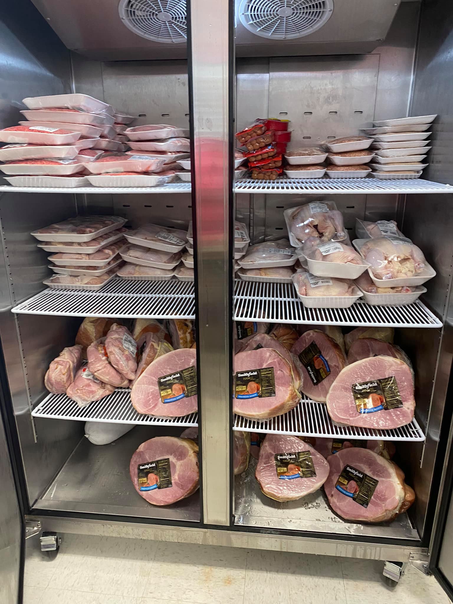 A refrigerator filled with hamburgers, hot dogs, chickens and hams in the food pantry at the Fort Lawn Community Center. 
