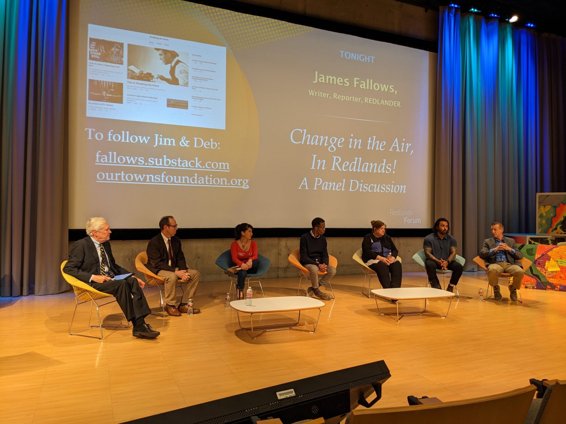 Seven people sitting on stage for a panel discussion.