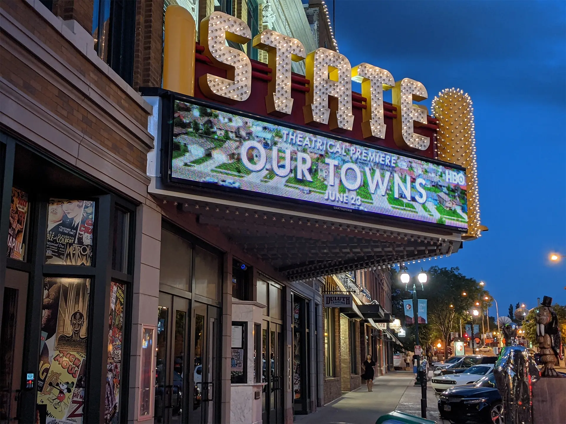 A lighted up outdoor marquee that displays the our towns movie logo.